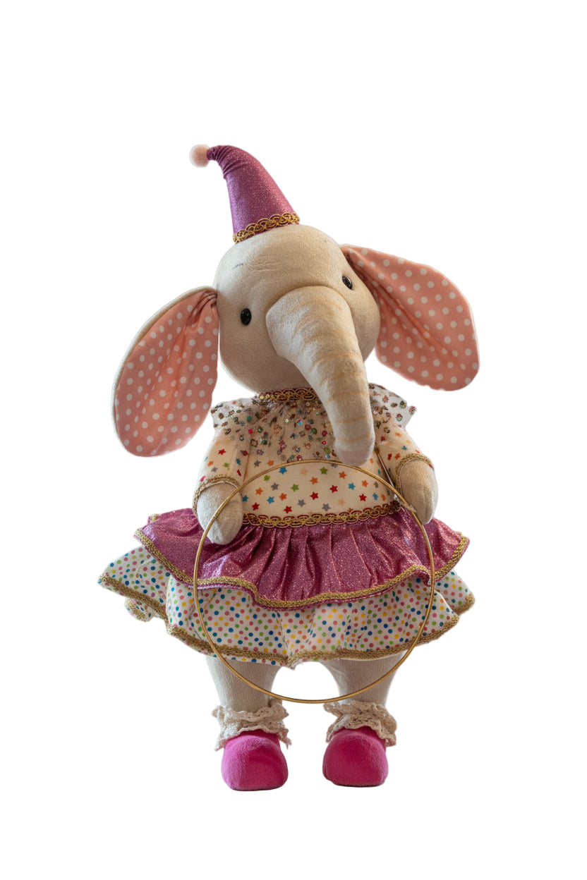 Decorative elephant plush toy in a polka dot dress and pink shoes on a decorative stand.